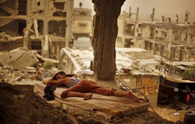 بالصورة.. شاب فلسطيني ينام على أنقاض منزله